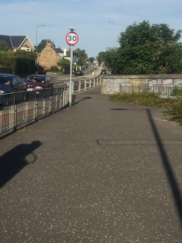 Fence protecting pedestrians from cars (good) but preventing access to Cyclepath from road (bad)